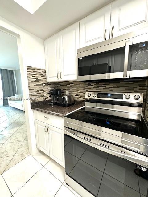 3505 S Ocean Dr Unit 419, Hollywood, FL 33019 - kitchen featuring appliances with stainless steel finishes, white cabinets, and decorative backsplash