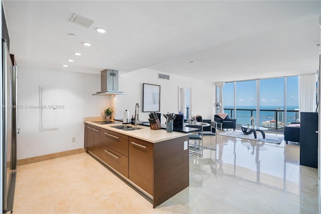 495 Brickell Unit 5705, Miami, FL 33131 - kitchen with wall chimney exhaust hood, modern cabinets, a peninsula, black electric stovetop, and expansive windows