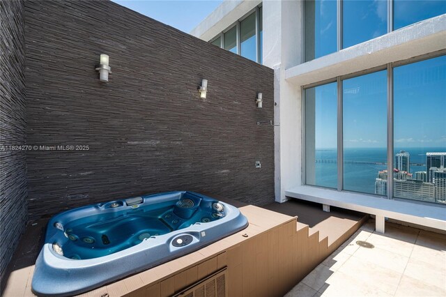 495 Brickell Unit 5705, Miami, FL 33131 - view of patio / terrace featuring a hot tub and a water view