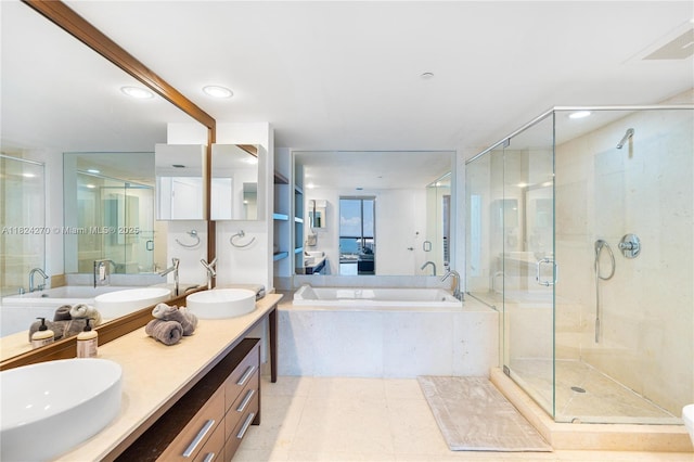 495 Brickell Unit 5705, Miami, FL 33131 - bathroom featuring a garden tub, double vanity, a shower stall, and recessed lighting