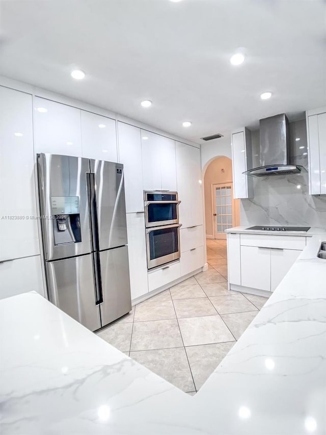 14332 SW 38th Ter, Miami, FL 33175 - kitchen featuring appliances with stainless steel finishes, modern cabinets, wall chimney range hood, arched walkways, and recessed lighting