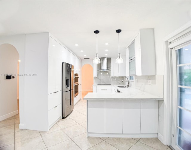 14332 SW 38th Ter, Miami, FL 33175 - kitchen featuring wall chimney range hood, arched walkways, stainless steel appliances, white cabinetry, and modern cabinets