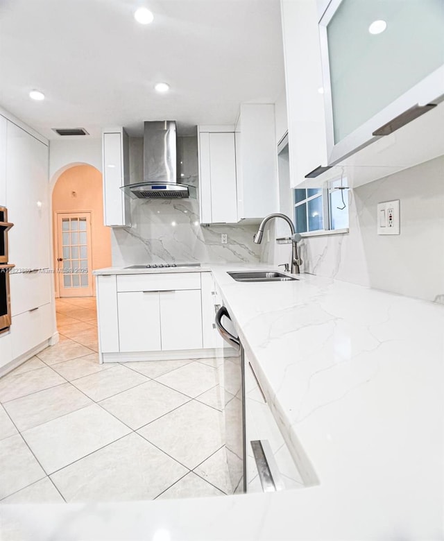 14332 SW 38th Ter, Miami, FL 33175 - kitchen with wall chimney exhaust hood, arched walkways, white cabinetry, dishwasher, and decorative backsplash