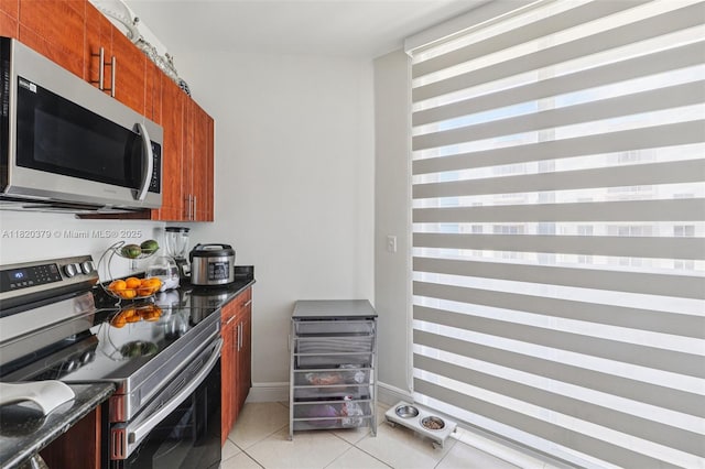 2425 SW 27th Ave Unit 705, Miami, FL 33145 - kitchen featuring stainless steel appliances, light tile patterned flooring, and brown cabinetry