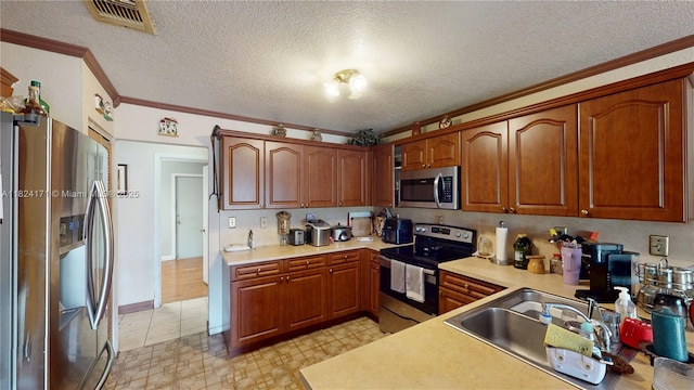 1000 SW 136th Pl, Miami, FL 33184 - kitchen with appliances with stainless steel finishes, ornamental molding, light countertops, brown cabinetry, and a textured ceiling