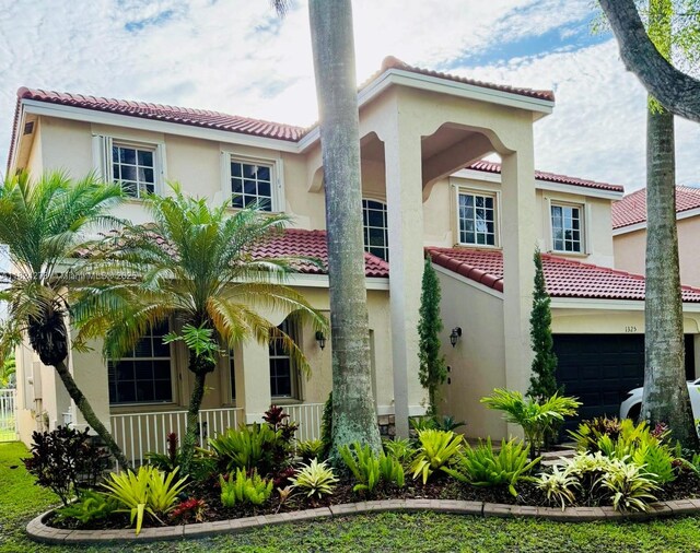 1325 Chenille Cir, Weston, FL 33327 - mediterranean / spanish house with a tile roof, a porch, stucco siding, and an attached garage