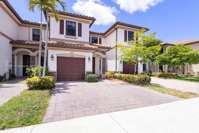 3324 W 90, Hialeah, FL 33018 - mediterranean / spanish house featuring a garage, decorative driveway, stone siding, stucco siding, and a tiled roof