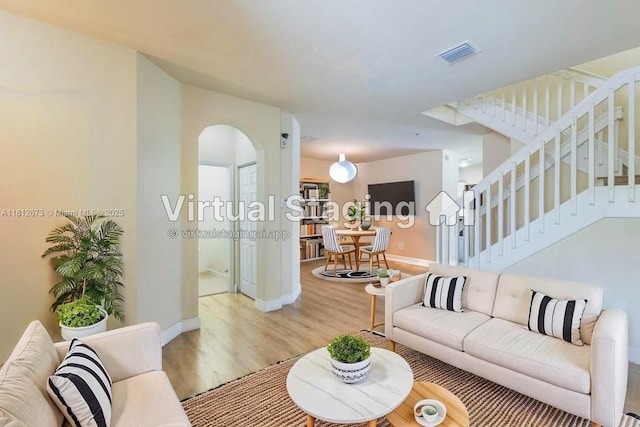3324 W 90, Hialeah, FL 33018 - living area featuring light wood-style flooring, stairs, and arched walkways