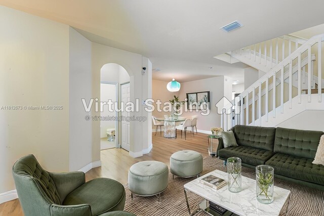 3324 W 90, Hialeah, FL 33018 - living area with light wood-type flooring, arched walkways, and stairway