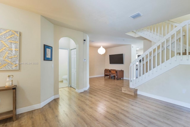 3324 W 90, Hialeah, FL 33018 - unfurnished living room featuring arched walkways, wood finished floors, and stairs