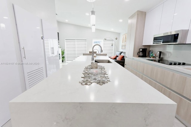 3813 SW 149th Pl, Miami, FL 33185 - kitchen featuring stainless steel microwave, modern cabinets, black electric stovetop, an island with sink, and light countertops