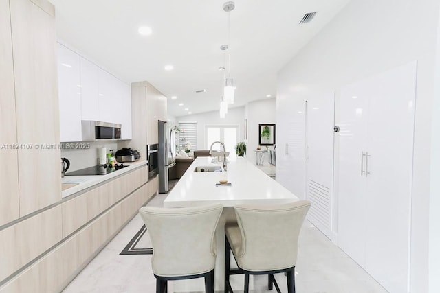 3813 SW 149th Pl, Miami, FL 33185 - kitchen featuring modern cabinets, stainless steel appliances, a breakfast bar area, light countertops, and a kitchen island with sink