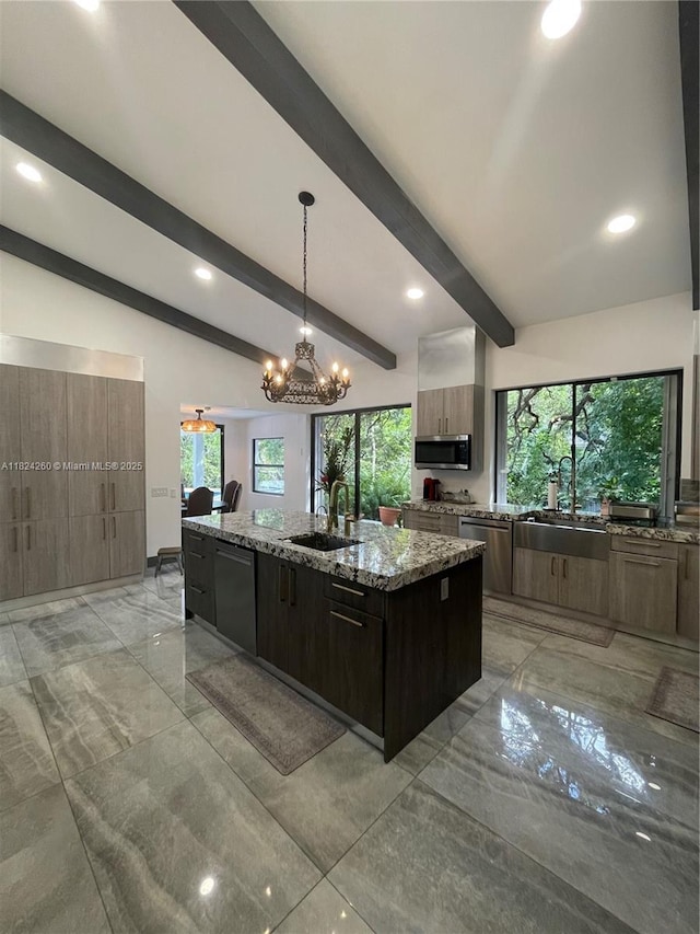 5811 SW 33rd Ter, Hollywood, FL 33312 - kitchen featuring stainless steel appliances, an island with sink, light marble finish floors, light stone counters, and plenty of natural light