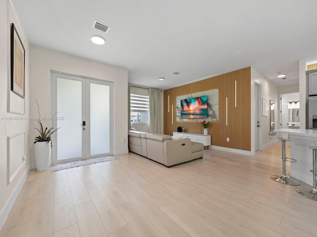 18100 SW 175th St, Miami, FL 33187 - living room featuring french doors, light wood-style flooring, wood walls, and an accent wall