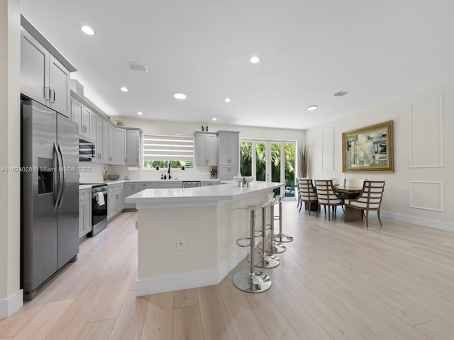 18100 SW 175th St, Miami, FL 33187 - kitchen featuring stainless steel appliances, gray cabinetry, light countertops, a breakfast bar area, and recessed lighting