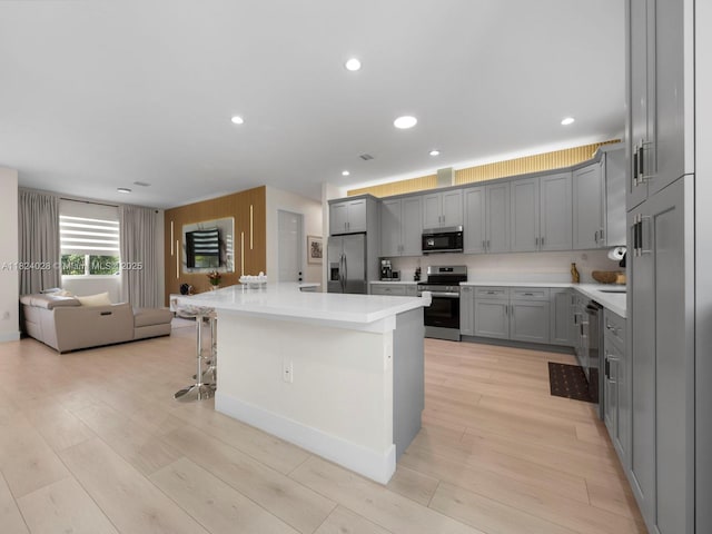 18100 SW 175th St, Miami, FL 33187 - kitchen featuring appliances with stainless steel finishes, gray cabinets, light wood-style floors, open floor plan, and recessed lighting