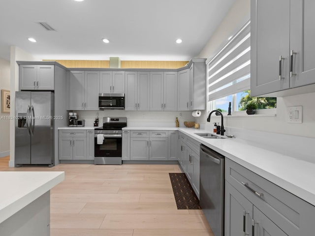 18100 SW 175th St, Miami, FL 33187 - kitchen featuring appliances with stainless steel finishes, gray cabinets, light wood finished floors, light countertops, and recessed lighting