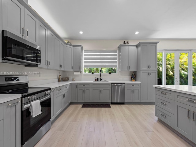 18100 SW 175th St, Miami, FL 33187 - kitchen featuring appliances with stainless steel finishes, gray cabinetry, light countertops, recessed lighting, and light wood-type flooring