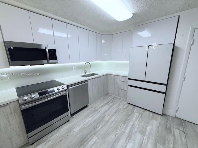 9352 S Belfort Cir Unit 109, Tamarac, FL 33321 - kitchen featuring appliances with stainless steel finishes, modern cabinets, a textured ceiling, white cabinetry, and light countertops