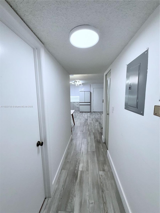 9352 S Belfort Cir Unit 109, Tamarac, FL 33321 - corridor featuring electric panel, light wood-style floors, and a textured ceiling