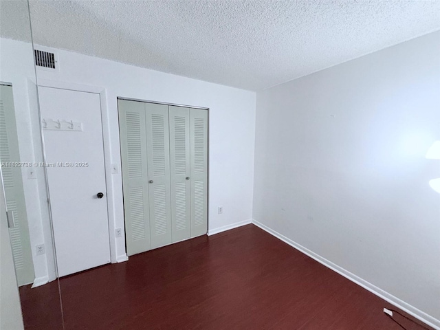 9352 S Belfort Cir Unit 109, Tamarac, FL 33321 - unfurnished bedroom with wood finished floors, a textured ceiling, and a closet