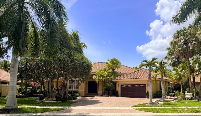 375 Sabal Way, Weston, FL 33326 - mediterranean / spanish-style house featuring an attached garage, decorative driveway, a tiled roof, and stucco siding
