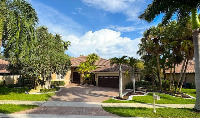 375 Sabal Way, Weston, FL 33326 - view of front facade with an attached garage, a tiled roof, decorative driveway, stucco siding, and a front lawn