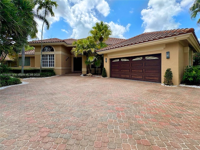 375 Sabal Way, Weston, FL 33326 - mediterranean / spanish home featuring stucco siding, decorative driveway, a garage, and a tile roof