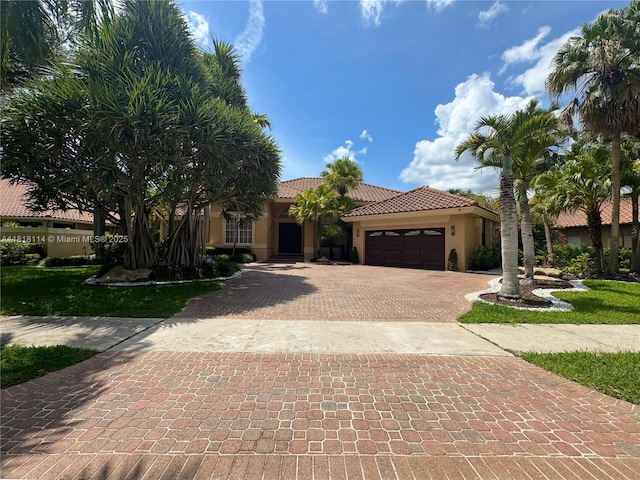 375 Sabal Way, Weston, FL 33326 - view of front facade featuring a garage, decorative driveway, stucco siding, and a tiled roof