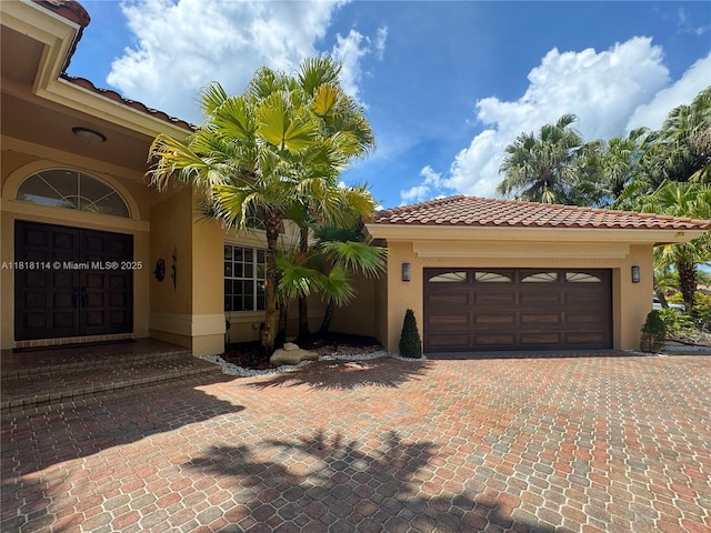 375 Sabal Way, Weston, FL 33326 - view of front facade with stucco siding, a garage, a tiled roof, and driveway