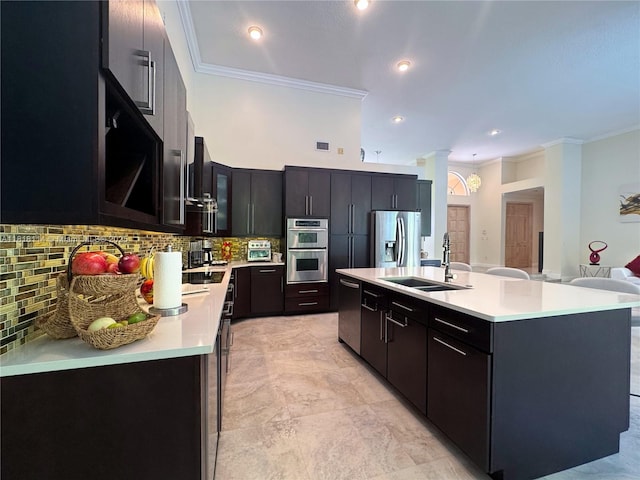 375 Sabal Way, Weston, FL 33326 - kitchen with appliances with stainless steel finishes, crown molding, light countertops, backsplash, and an island with sink