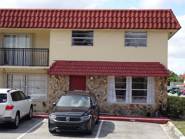6680 SW 41st Pl Unit 32, Davie, FL 33314 - view of property with stone siding, uncovered parking, and a tiled roof