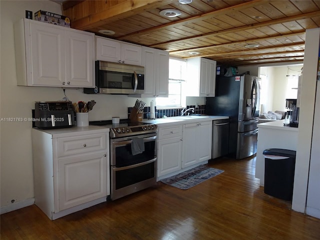 6680 SW 41st Pl Unit 32, Davie, FL 33314 - kitchen featuring appliances with stainless steel finishes, a wood ceiling with exposed beams, dark wood finished floors, white cabinetry, and light countertops