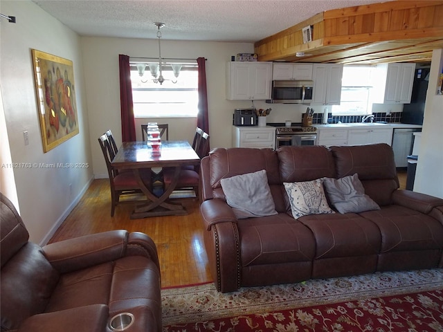 6680 SW 41st Pl Unit 32, Davie, FL 33314 - living room featuring a chandelier, light wood-style floors, and a textured ceiling