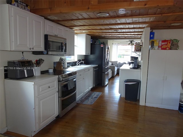 6680 SW 41st Pl Unit 32, Davie, FL 33314 - kitchen featuring stainless steel appliances, a wood ceiling with exposed beams, wood finished floors, white cabinets, and light countertops
