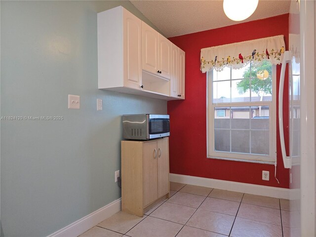9410 S Meadows Cir, Miramar, FL 33025 - kitchen featuring stainless steel microwave, white cabinetry, and light tile patterned floors