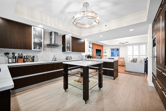 2711 S Ocean Dr Unit 3003, Hollywood, FL 33019 - kitchen with wall chimney range hood, a tray ceiling, modern cabinets, a chandelier, and recessed lighting