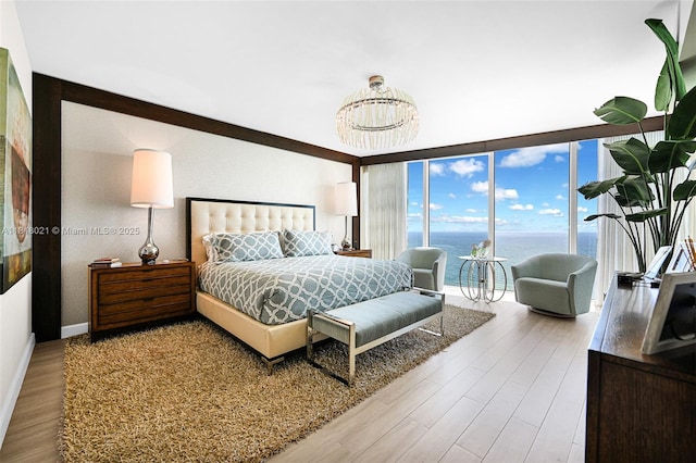 2711 S Ocean Dr Unit 3003, Hollywood, FL 33019 - bedroom with wood finished floors, a water view, a chandelier, and expansive windows