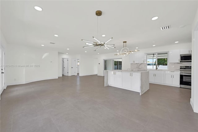 3917 Adams St, Hollywood, FL 33021 - kitchen with stainless steel appliances, a chandelier, white cabinets, recessed lighting, and a center island