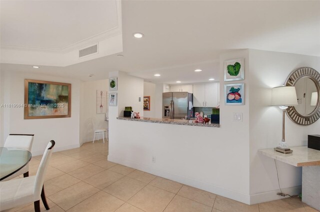 140 SE 5th Ave Unit 438, Boca Raton, FL 33432 - kitchen with stainless steel fridge, white cabinetry, recessed lighting, light tile patterned floors, and a peninsula