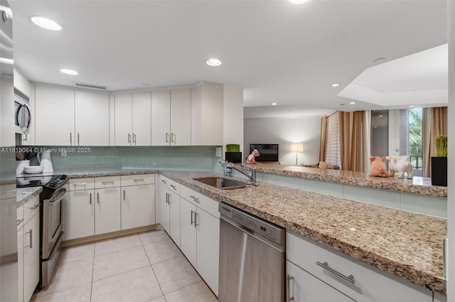 140 SE 5th Ave Unit 438, Boca Raton, FL 33432 - kitchen featuring appliances with stainless steel finishes, tasteful backsplash, light stone counters, light tile patterned flooring, and white cabinets
