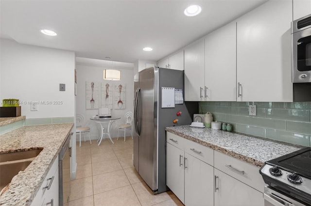 140 SE 5th Ave Unit 438, Boca Raton, FL 33432 - kitchen with stainless steel appliances, white cabinetry, light tile patterned floors, tasteful backsplash, and recessed lighting