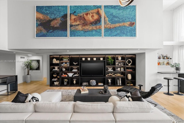 4701 N Meridian Ave Unit 217, Miami Beach, FL 33140 - living room with a high ceiling, a bar, and wood finished floors