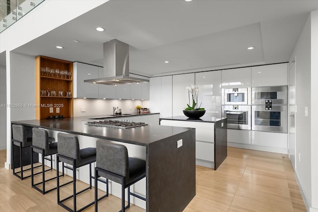 4701 N Meridian Ave Unit 217, Miami Beach, FL 33140 - kitchen with modern cabinets, island range hood, dark countertops, a peninsula, and white cabinetry