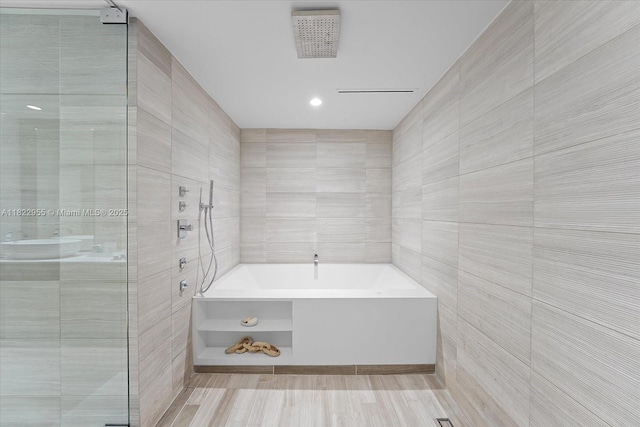 4701 N Meridian Ave Unit 217, Miami Beach, FL 33140 - bathroom with tile walls, a garden tub, and a tile shower