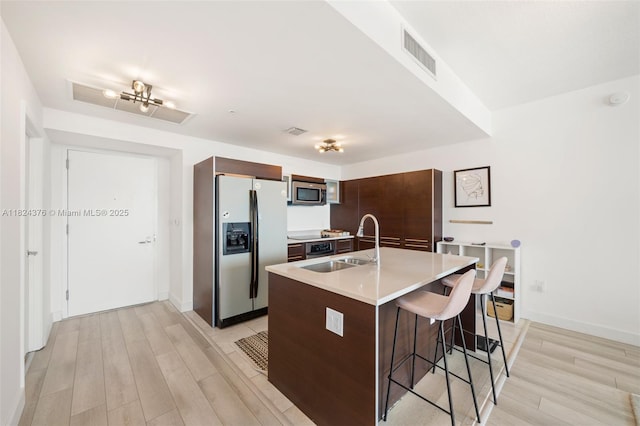 1900 N Bayshore Dr Unit 2514, Miami, FL 33132 - kitchen with stainless steel appliances, light wood finished floors, a kitchen breakfast bar, light countertops, and an island with sink