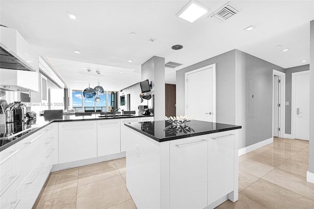 17121 Collins Ave Unit 2304, Sunny Isles Beach, FL 33160 - kitchen featuring dark countertops, white cabinetry, a kitchen island, modern cabinets, and a peninsula