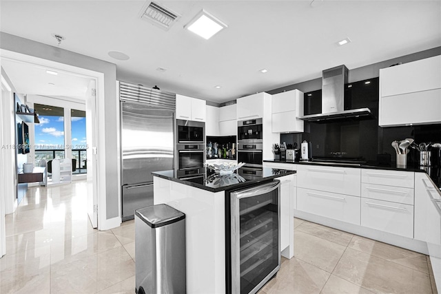 17121 Collins Ave Unit 2304, Sunny Isles Beach, FL 33160 - kitchen featuring built in appliances, wall chimney exhaust hood, beverage cooler, dark countertops, and recessed lighting