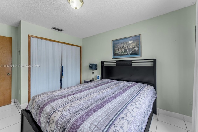 14548 SW 98th Ter, Miami, FL 33186 - bedroom featuring light tile patterned floors, a closet, and a textured ceiling