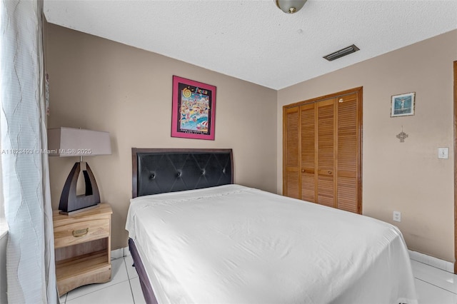 14548 SW 98th Ter, Miami, FL 33186 - bedroom with a closet, light tile patterned floors, and a textured ceiling